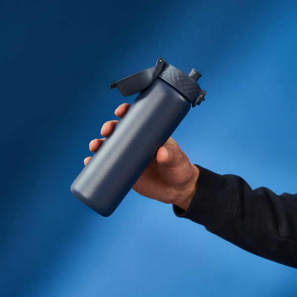 A dark gray water bottle stands upright with a flip-top lid and textured grip on a plain white background. Branding on the bottle reads ION8.