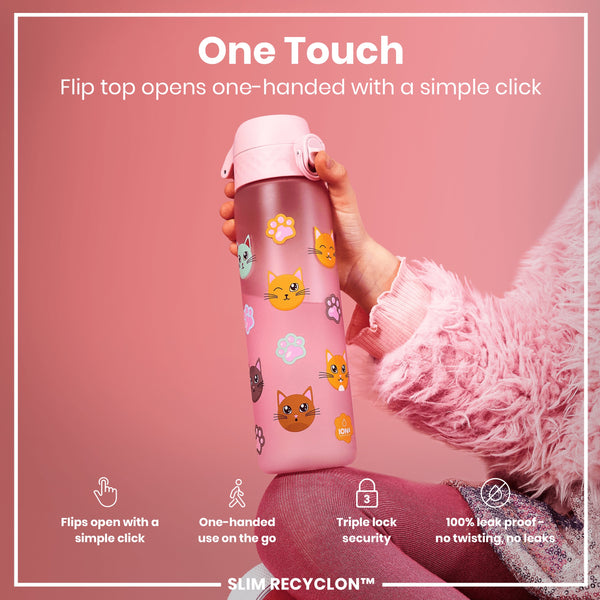 A pink water bottle, featuring cat and paw print designs, is being held; its flip top opens with a single click. The bottle is in the hand of someone wearing a fluffy pink sweater against a pink background. Flip top opens one-handed with a simple click. One-handed use on the go. Triple lock security. 100% leak proof - no twisting, no leaks. SLIM RECYCLON™.