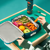 A rectangular teal lunchbox showcases colorful cartoon vehicles including cars, buses, and trucks with road signs such as 