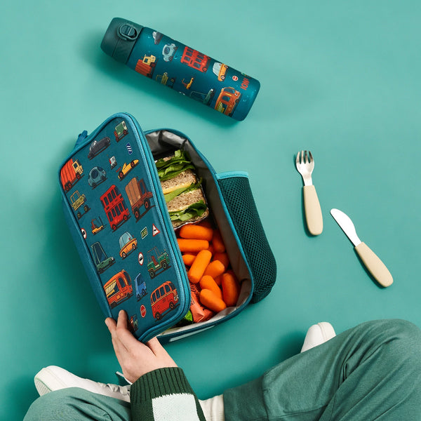 A rectangular teal lunchbox showcases colorful cartoon vehicles including cars, buses, and trucks with road signs such as "Stop" and "A68" in a playful pattern.