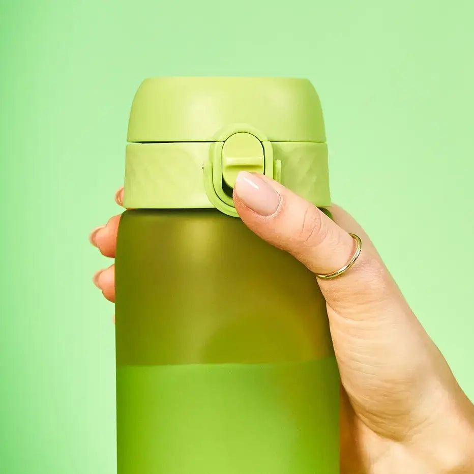 A green water bottle is being held; a finger presses the lid's button. The background is a solid light green.